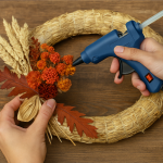 Mabon Preparations: Easy Crafts & Rituals for the Autumn Equinox 4 Finished harvest wreath with pinecones, apples, and ribbon on a rustic wooden door.