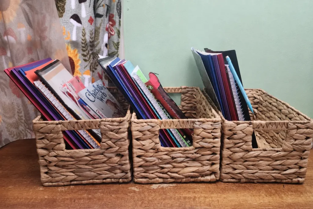 Journals and notebooks organized into woven baskets while clearing a cluttered room