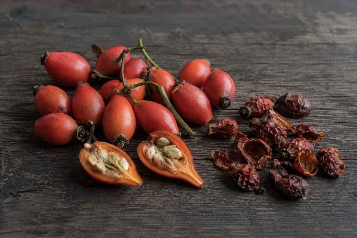 Top 10 Best Herbal Teas for Cold & Flu Season 8 Fresh, cut, and dried rose hips on a wooden surface